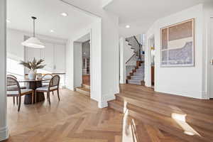 Dining area with parquet flooring and recessed lighting