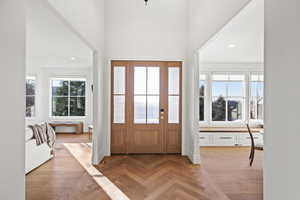 Foyer featuring parquet flooring, recessed lighting, plenty of natural light, and a high ceiling