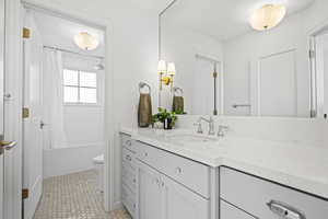 Bathroom featuring vanity, shower / tub combo with curtain, and light tile patterned flooring
