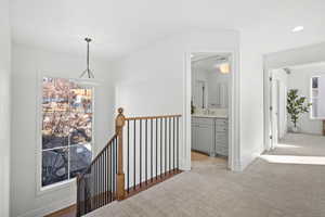 Hall featuring light colored carpet, an upstairs landing, and recessed lighting