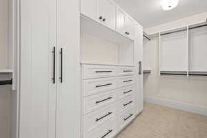 Walk in closet with light carpet