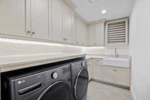 Laundry room with cabinet space, washer and clothes dryer, parquet flooring, and recessed lighting