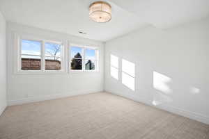 Spare room featuring baseboards and light colored carpet