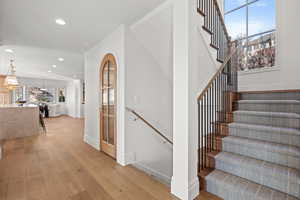 Stairs with hardwood / wood-style flooring and recessed lighting