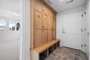 Mudroom featuring stone finish flooring and baseboards