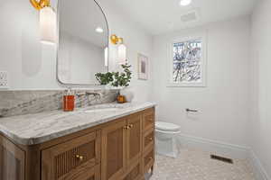 Half bathroom with vanity, recessed lighting, and light tile patterned floors