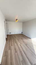 Empty room with light wood-type flooring and baseboards