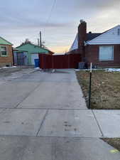 View of property exterior with a chimney, brick siding, and an outdoor structure