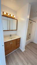 Full bathroom featuring shower / bath combination with curtain, vanity, light wood-type flooring, and a textured ceiling