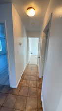 Corridor with baseboards and tile patterned floors