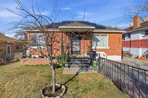 View of front of home with solar panels and brick siding