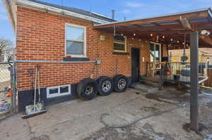 Rear view of property with brick siding and a deck
