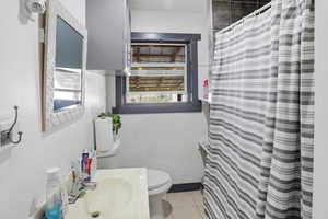 Full bath featuring vanity, a shower with shower curtain, and light tile patterned flooring