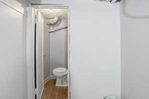 Bathroom with toilet and wood finished floors