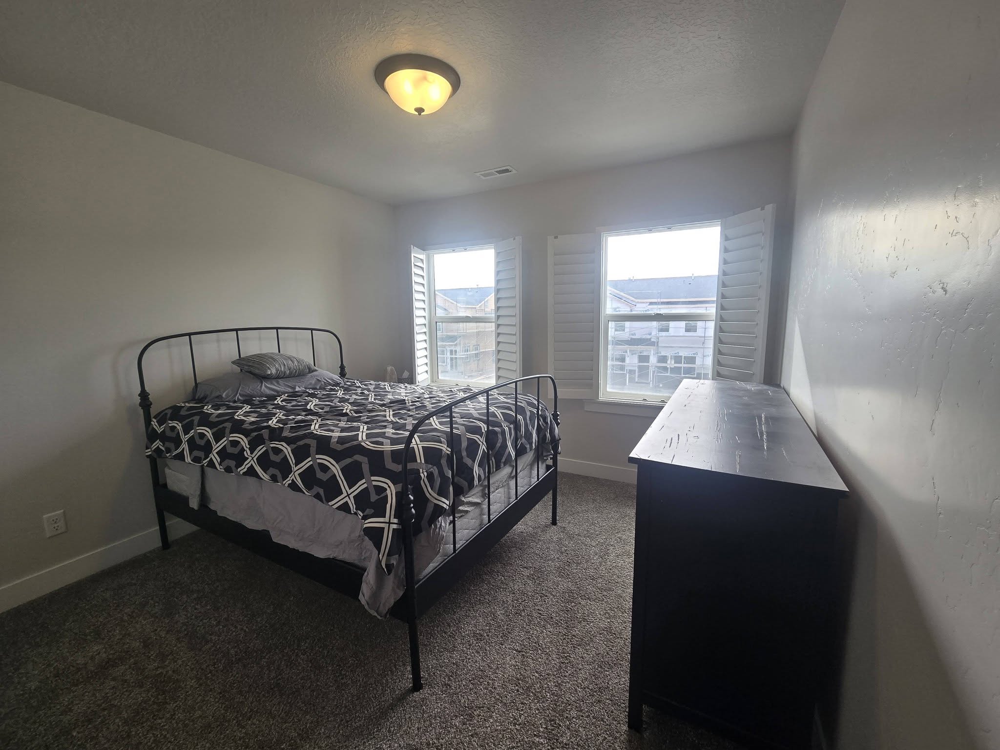 Bedroom featuring dark carpet and a textured ceiling