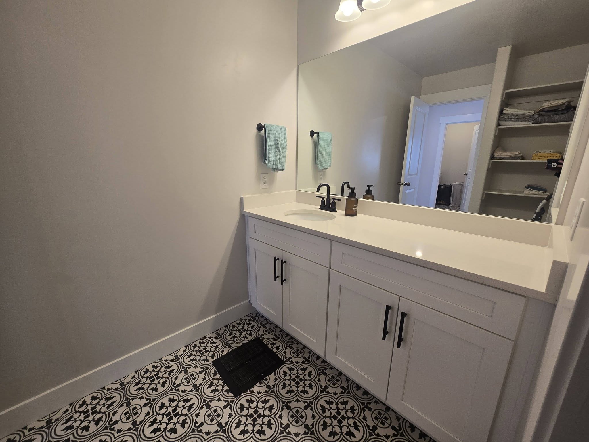 Bathroom with vanity, tile patterned flooring, and a spacious closet
