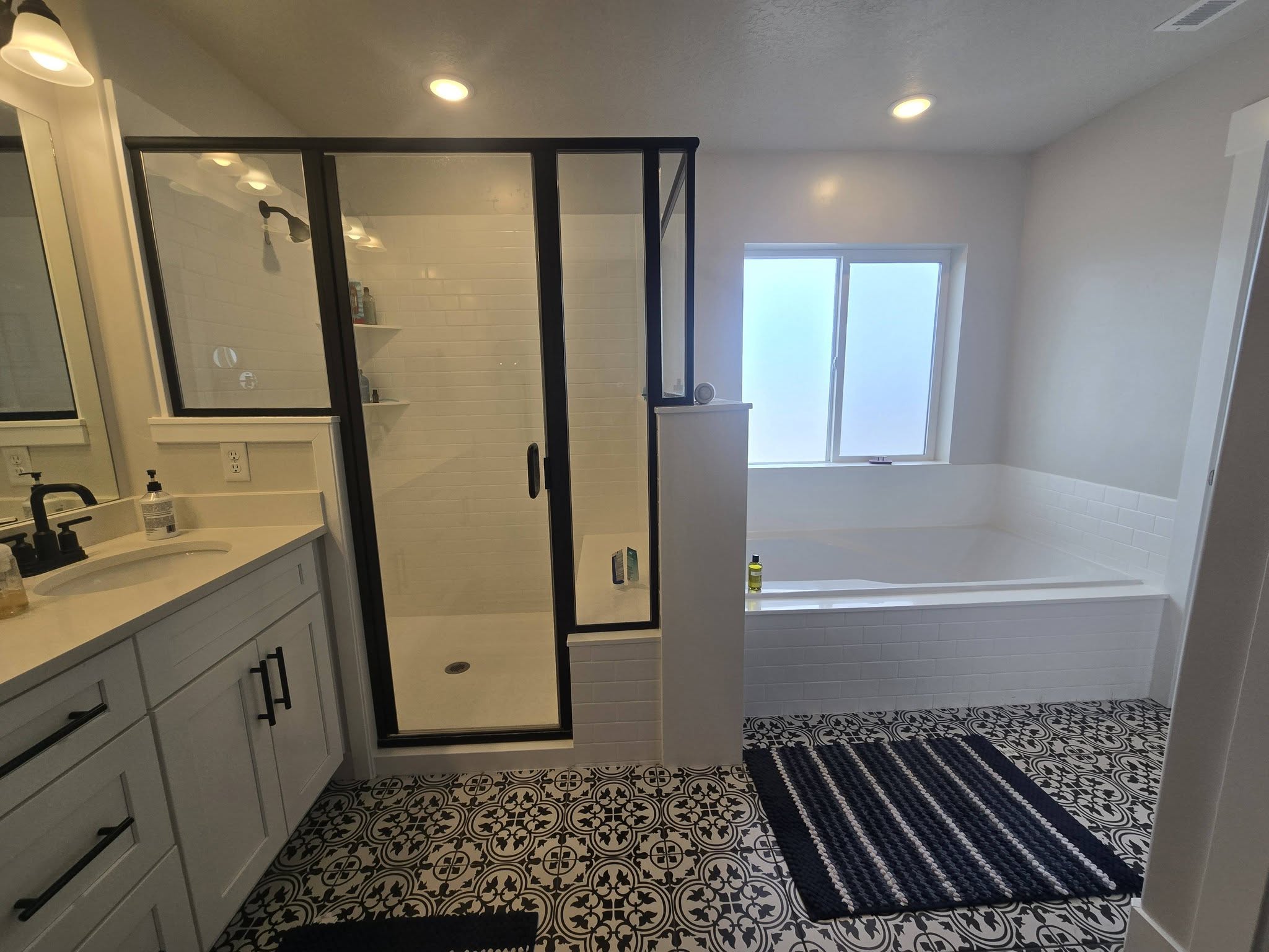Bathroom with vanity, a garden tub, a shower stall, light tile patterned floors, and recessed lighting