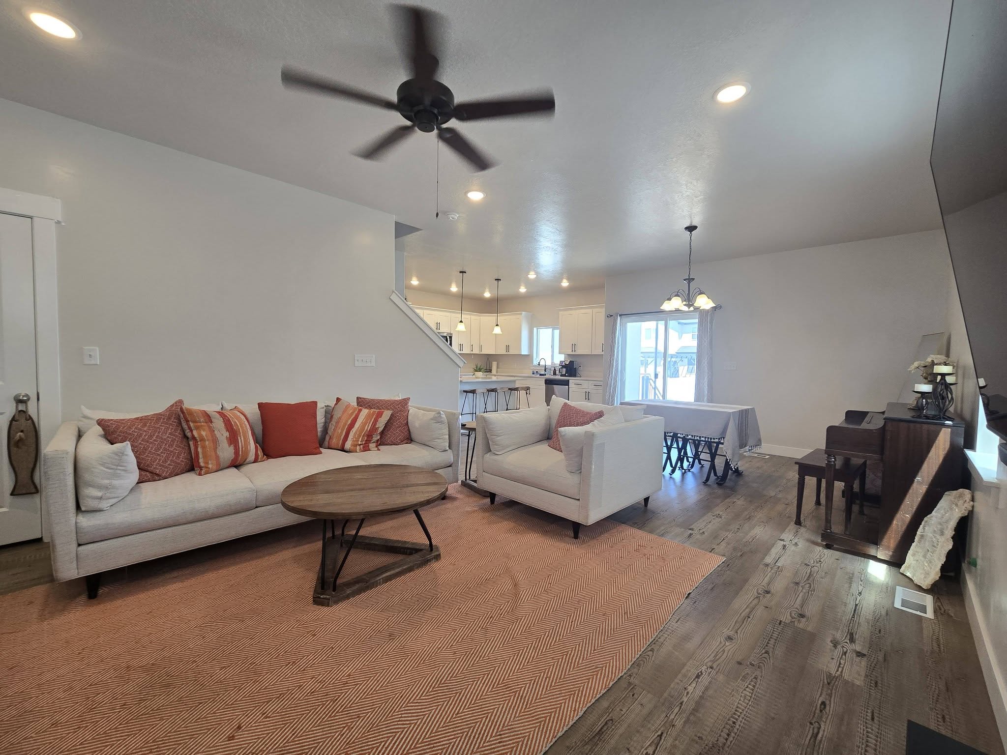 Living area featuring ceiling fan, a chandelier, and wood finished floors