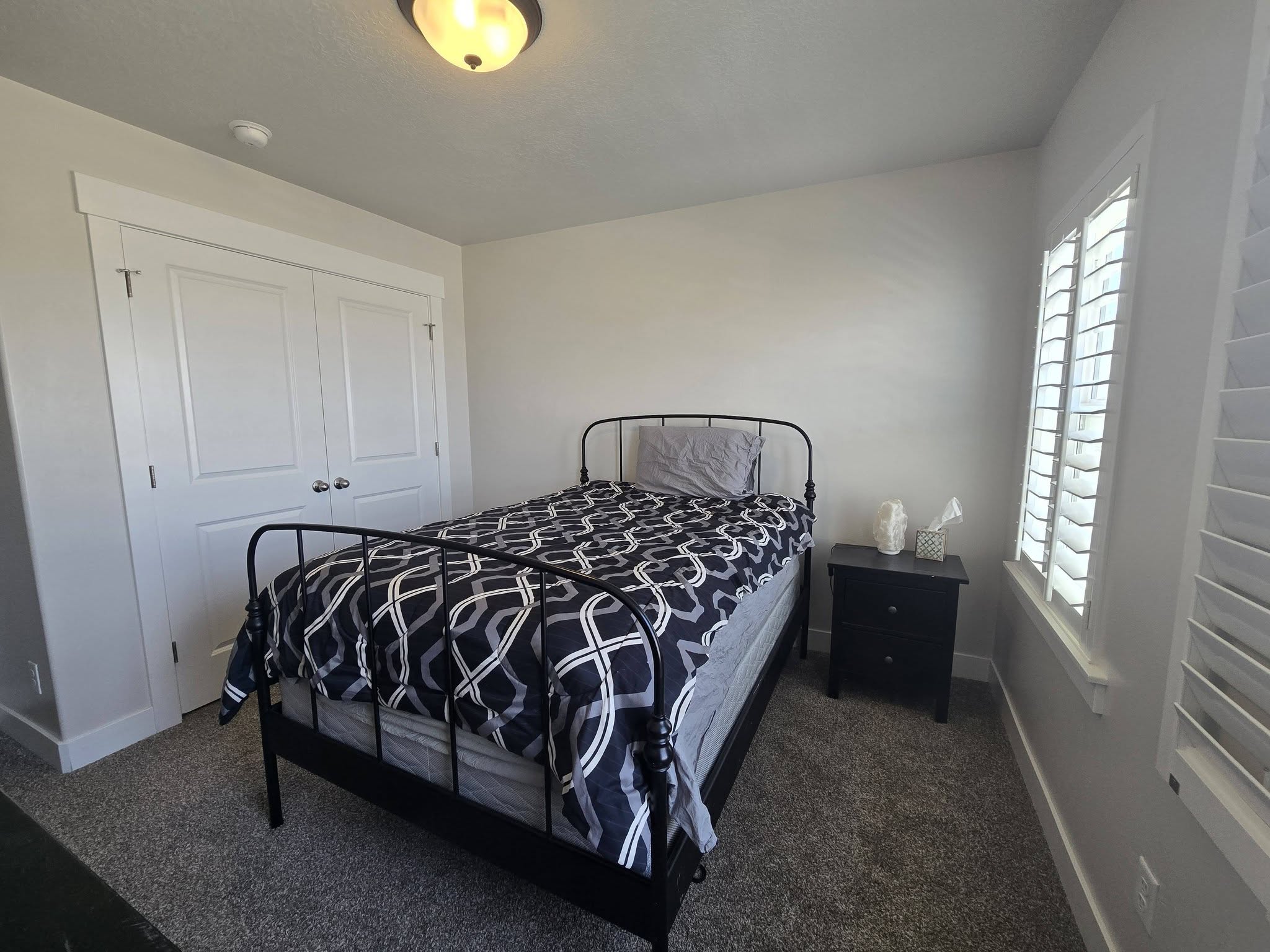 Bedroom featuring dark colored carpet and a closet