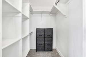 Primary Walk in closet with light colored carpet