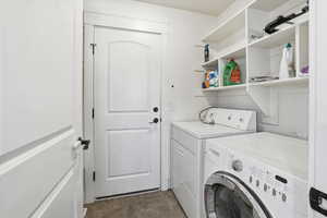 Laundry room with washer and dryer and shelving