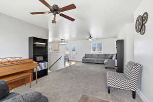 Carpeted living area with a ceiling fan