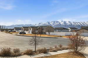 View of asphalt road featuring sidewalks, a mountain view, and a residential view