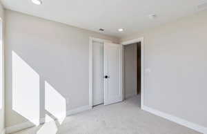 Bedroom 4 featuring light colored carpet and recessed lighting