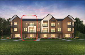 View of front of home with a yard and two balconies