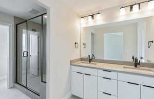 Owner's Bathroom with double vanity, a stall shower, and light tile patterned floors