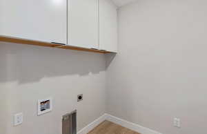 Laundry room with cabinet space, light wood-style floors, hookup for an electric dryer, and washer hookup
