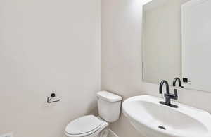 Half bathroom featuring a sink and toilet