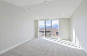 Owner's Suite featuring a mountain view, expansive windows, lofted ceiling, and recessed lighting
