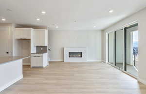Unfurnished living room with light wood-style floors, a tile fireplace, and recessed lighting