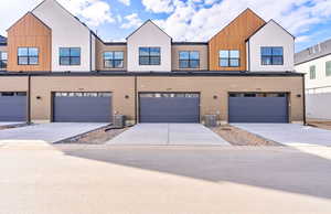 View of front of property with concrete driveway and an attached garage