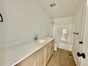 Bathroom with vanity, light wood-style flooring, and shower / bath combination