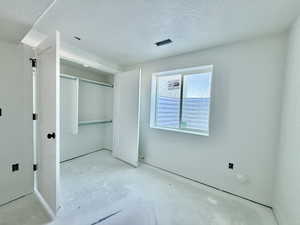 Unfurnished bedroom featuring a closet and a textured ceiling