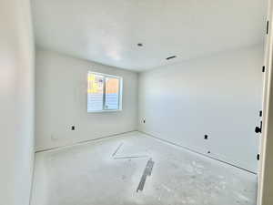 Unfurnished room with a textured ceiling