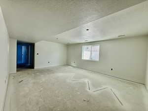 Spare room featuring a textured ceiling and baseboards