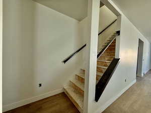 Staircase featuring hardwood / wood-style flooring