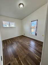 Spare room with baseboards and dark wood finished floors