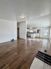 Unfurnished living room featuring dark wood finished floors and a textured ceiling