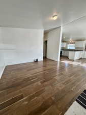 Unfurnished living room featuring dark wood finished floors and baseboards