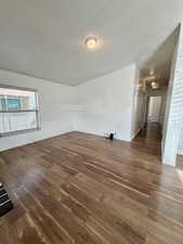 Empty room with a textured ceiling and dark wood finished floors