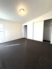 Unfurnished bedroom featuring a textured ceiling, carpet, and a closet