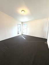 Carpeted empty room featuring a textured ceiling