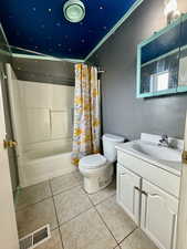 Full bath with shower / tub combo, vanity, and light tile patterned floors