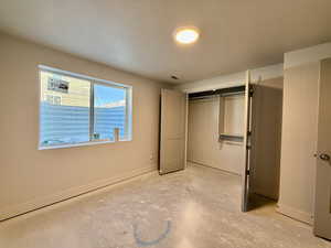 Unfurnished bedroom with concrete flooring and a closet