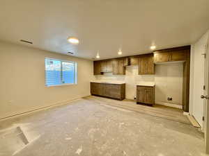 Kitchen with wood finish cabinets, light countertops, and recessed lighting