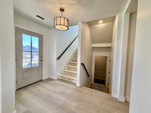 Entryway with stairs and light wood-style flooring